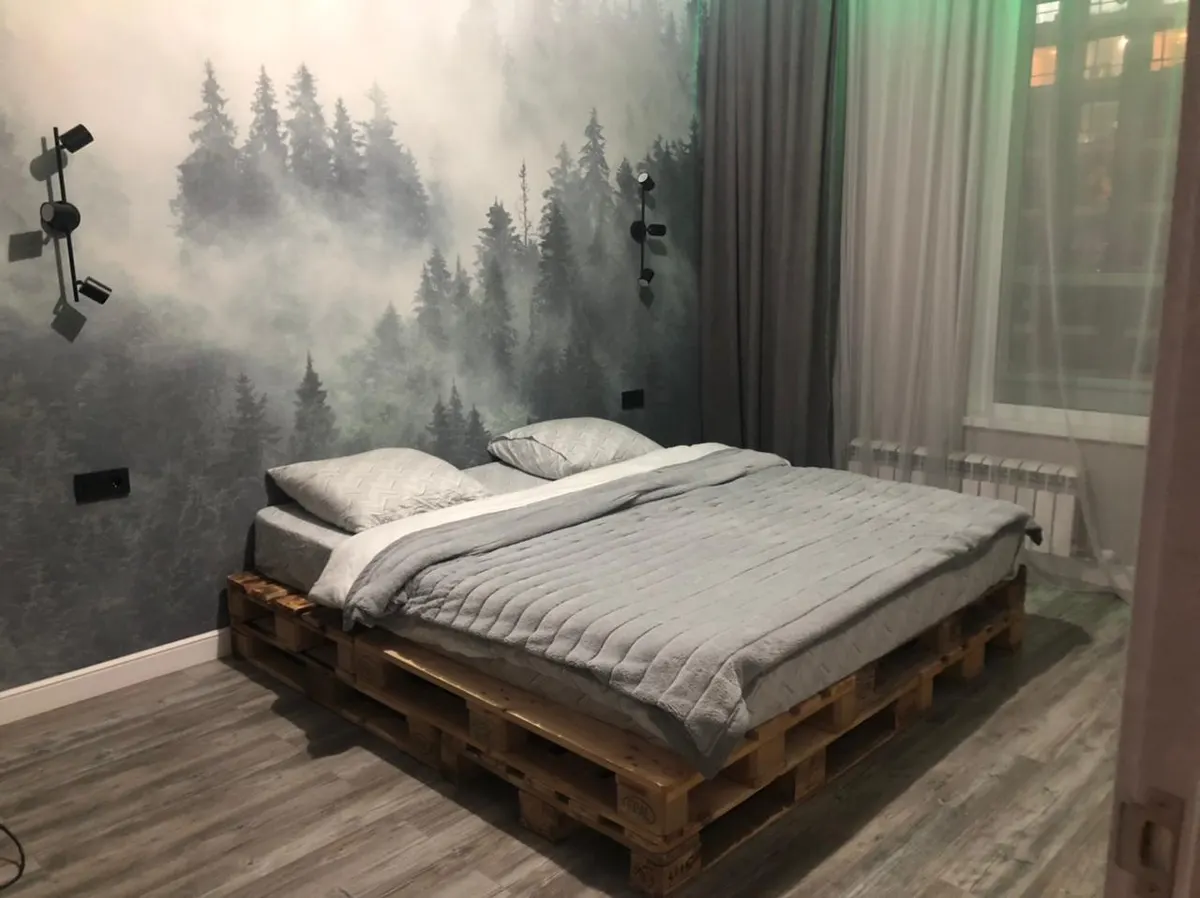 Фотообои с туманным лесом за кроватью в спальне